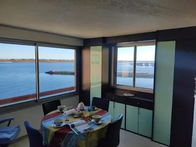 a dining room with a table and a view of the water at T2 Spacieux, Proche Plage, Parking Privé - FR-1-796-82 in Gruissan