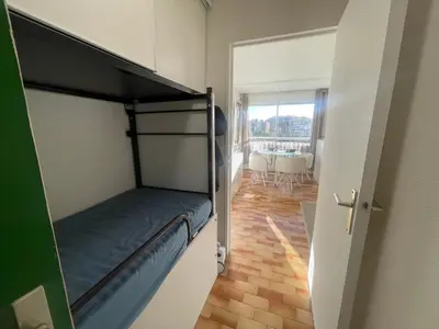 a bunk bed in a room with a view of a dining room at Studio rénové, proche port & village, parking, animaux admis - FR-1-796-83 in Gruissan