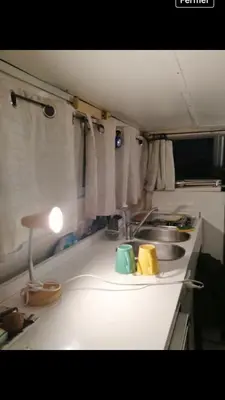 a kitchen counter with a sink and a lamp at vacances de rêve sur les vagues in Gruissan