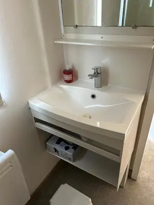 a bathroom with a white sink and a mirror at Mobil-home 3 ch camping TOHAPI in Port-la-Nouvelle
