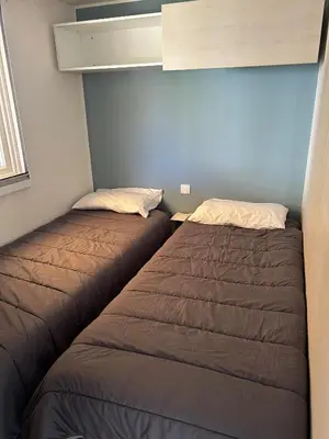 two beds sitting next to each other in a room at Mobil-home 3 ch camping TOHAPI in Port-la-Nouvelle