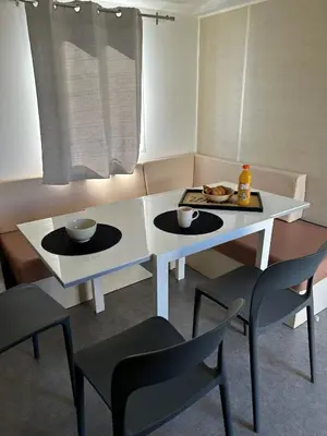 a white table and chairs with a tray of food on it at Mobil-home 3 ch camping TOHAPI in Port-la-Nouvelle