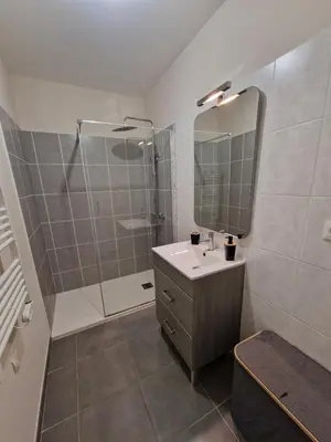 a bathroom with a shower and a sink and a mirror at Villa avec piscine privée in Sallèles-dʼAude