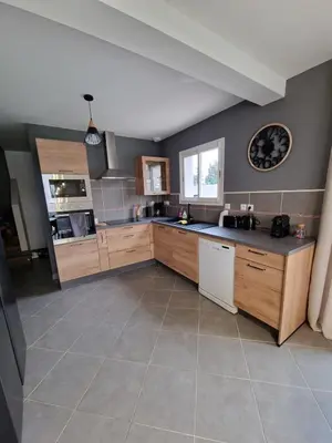 a large kitchen with wooden cabinets and a sink at Villa avec piscine privée in Sallèles-dʼAude