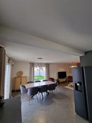a dining table and chairs in a living room at Villa avec piscine privée in Sallèles-dʼAude