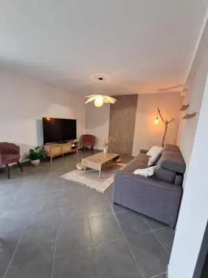 a living room with a couch and a tv at Villa avec piscine privée in Sallèles-dʼAude