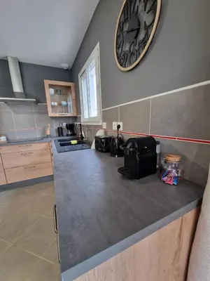 a kitchen with a counter with a clock on the wall at Villa avec piscine privée in Sallèles-dʼAude