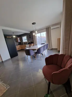 a dining room and living room with a table and chairs at Villa avec piscine privée in Sallèles-dʼAude