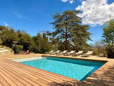 a swimming pool with lounge chairs and a tree at Chambre avec vue in Carcassonne