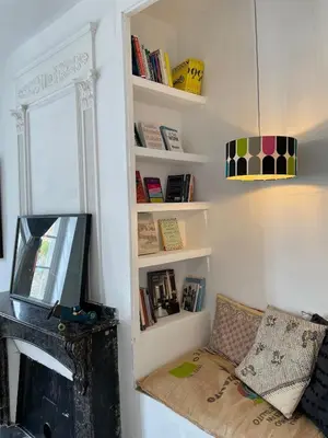 a living room with a tv and a shelf with books at Artist Residence - courtyard, terrace, Grand Piano in Siran