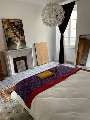 a bedroom with a large bed and a chandelier at Artist Residence - courtyard, terrace, Grand Piano in Siran