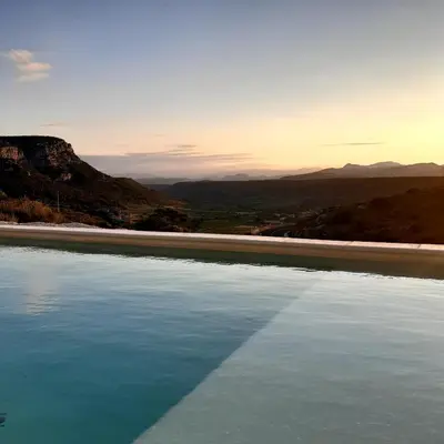 a pool of water with mountains in the background at Alzina in Vingrau