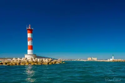 a lighthouse on a rock island in the water at Mobil-home Port la Nouvelle in Port-la-Nouvelle