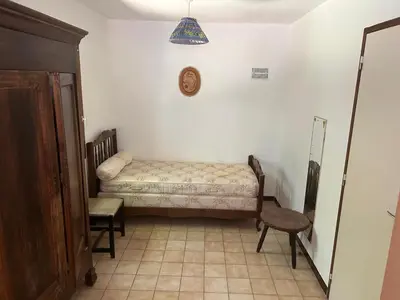 a small room with a bed and a chair at Maison de Vacances in Pradelles-Cabardès