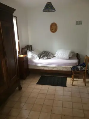 a bedroom with two beds and a cat laying on the bed at Maison de Vacances in Pradelles-Cabardès