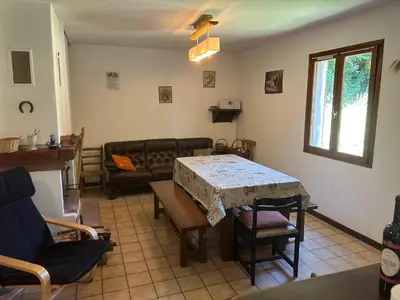 a living room with a table and a couch at Maison de Vacances in Pradelles-Cabardès