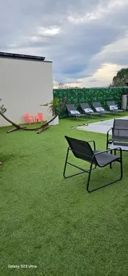 a group of chairs sitting on a field of grass at Villa moderne avec piscine privée in Roubia