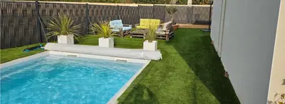 a small backyard with a swimming pool and grass at Villa moderne avec piscine privée in Roubia