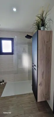 a bathroom with a shower with a glass wall at Villa moderne avec piscine privée in Roubia