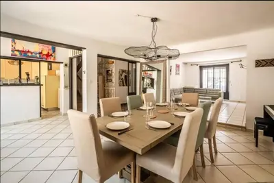 a dining room and living room with a table and chairs at Comme une évidence in Carcassonne