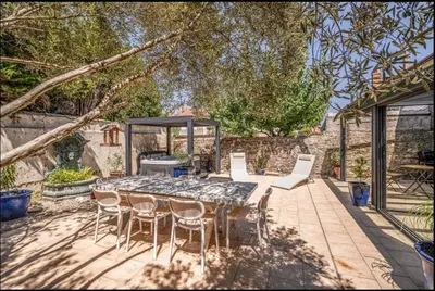a patio with a table and chairs and a gazebo at Comme une évidence in Carcassonne