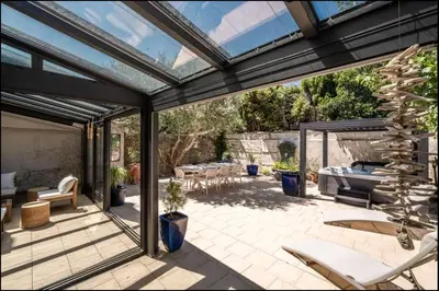 a patio with a glassconservatory with a table and chairs at Comme une évidence in Carcassonne