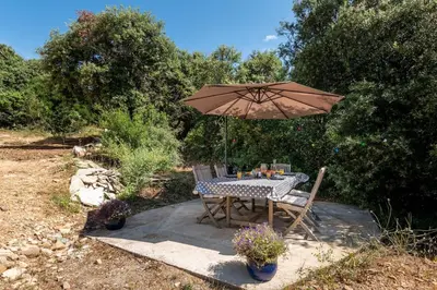 a table and chairs under an umbrella in a yard at Gite la Bonté, chaleureux avec une vue enchantée in Vélieux