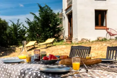 a table with a plate of fruit and juice on it at Gite la Bonté, chaleureux avec une vue enchantée in Vélieux