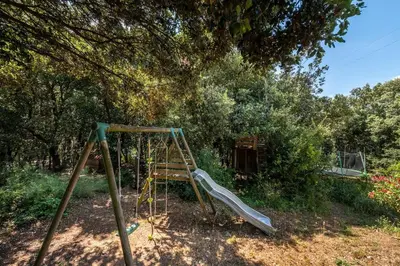 a playground with a slide in a yard at Gite la Bonté, chaleureux avec une vue enchantée in Vélieux