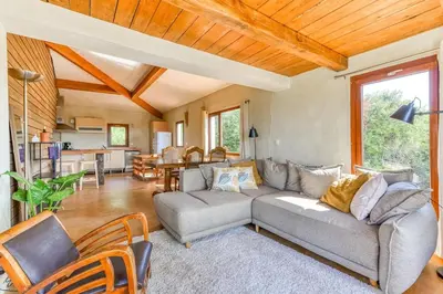 a living room with a couch and a table at Gite la Bonté, chaleureux avec une vue enchantée in Vélieux