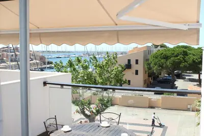 a balcony with a table and chairs and a view of a harbor at Appartement avec grande terrasse vue panoramique GN400-024 in Gruissan