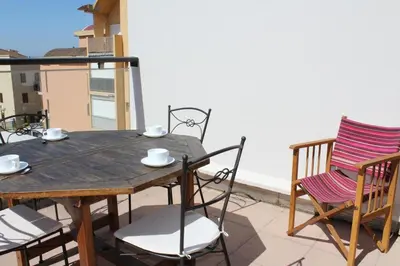 a wooden table and chairs on a balcony at Appartement avec grande terrasse vue panoramique GN400-024 in Gruissan
