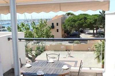a table on a balcony with a view of a street at Appartement avec grande terrasse vue panoramique GN400-024 in Gruissan