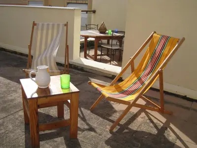 two rocking chairs and a table with a vase on it at Appartement avec grande terrasse vue panoramique GN400-024 in Gruissan