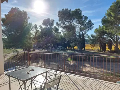 a table and chairs on a balcony with a fence at House on winery in Azille