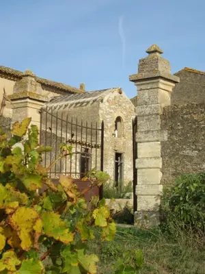 an old stone building with a gate in front of it at House on winery in Azille