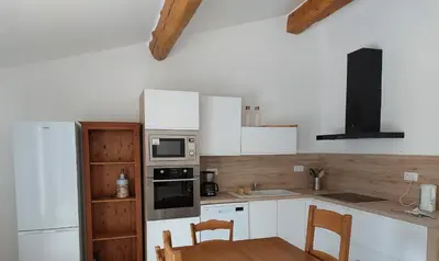 a kitchen with white appliances and a table and chairs at House on winery in Azille