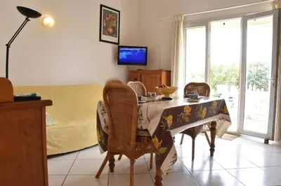 a living room with a table with chairs and a couch at Villa avec terrasse et garage proche plage GA120-038 in Gruissan