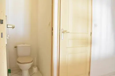 a small bathroom with a toilet and a door at Villa avec terrasse et garage proche plage GA120-038 in Gruissan