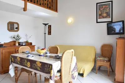 a living room with a table and chairs and a couch at Villa avec terrasse et garage proche plage GA120-038 in Gruissan