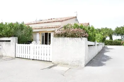 a white fence in front of a white house at Villa avec terrasse et garage proche plage GA120-038 in Gruissan