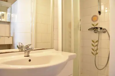 a white bathroom with a sink and a shower at Appartement 2 pièces - Gruissan GN580-028 in Gruissan