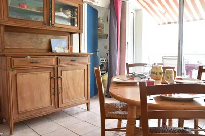 a dining room with a table and a large wooden cabinet at Appartement 2 pièces - Gruissan GN580-028 in Gruissan