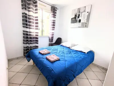 a bedroom with a blue bed with two towels on it at Villa Le Jardin des Délices - de 2 à 8 personnes avec Piscine in Raissac-dʼAude