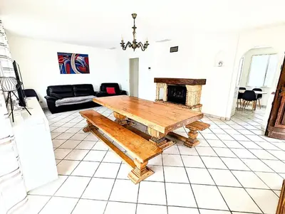 a living room with a table and a fireplace at Villa Le Jardin des Délices - de 2 à 8 personnes avec Piscine in Raissac-dʼAude