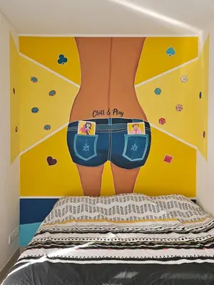 a bedroom with a bed with a wall with a picture of a person in shorts at POP ART Casino vibe! in Gruissan