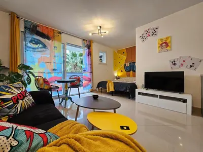 a living room with a couch and a tv at POP ART Casino vibe! in Gruissan