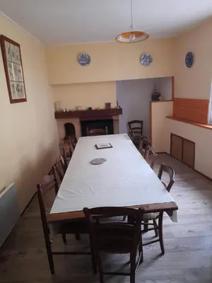 a dining room with a large table and chairs at la tute de l'ours in Roquefeuil