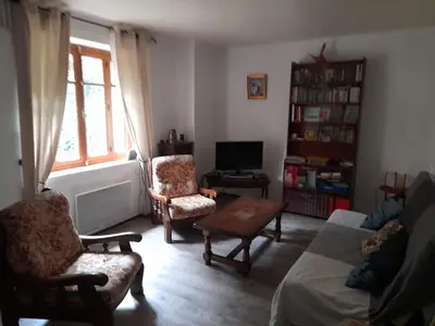 a living room with a couch and chairs and a tv at la tute de l'ours in Roquefeuil