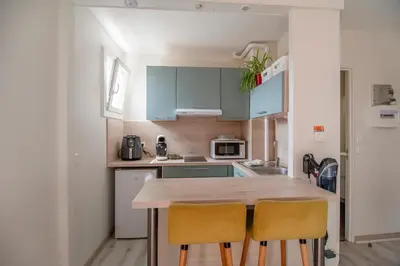 a kitchen with a wooden table and two yellow chairs at Les Cèdres - grand studio - neuf in Castres